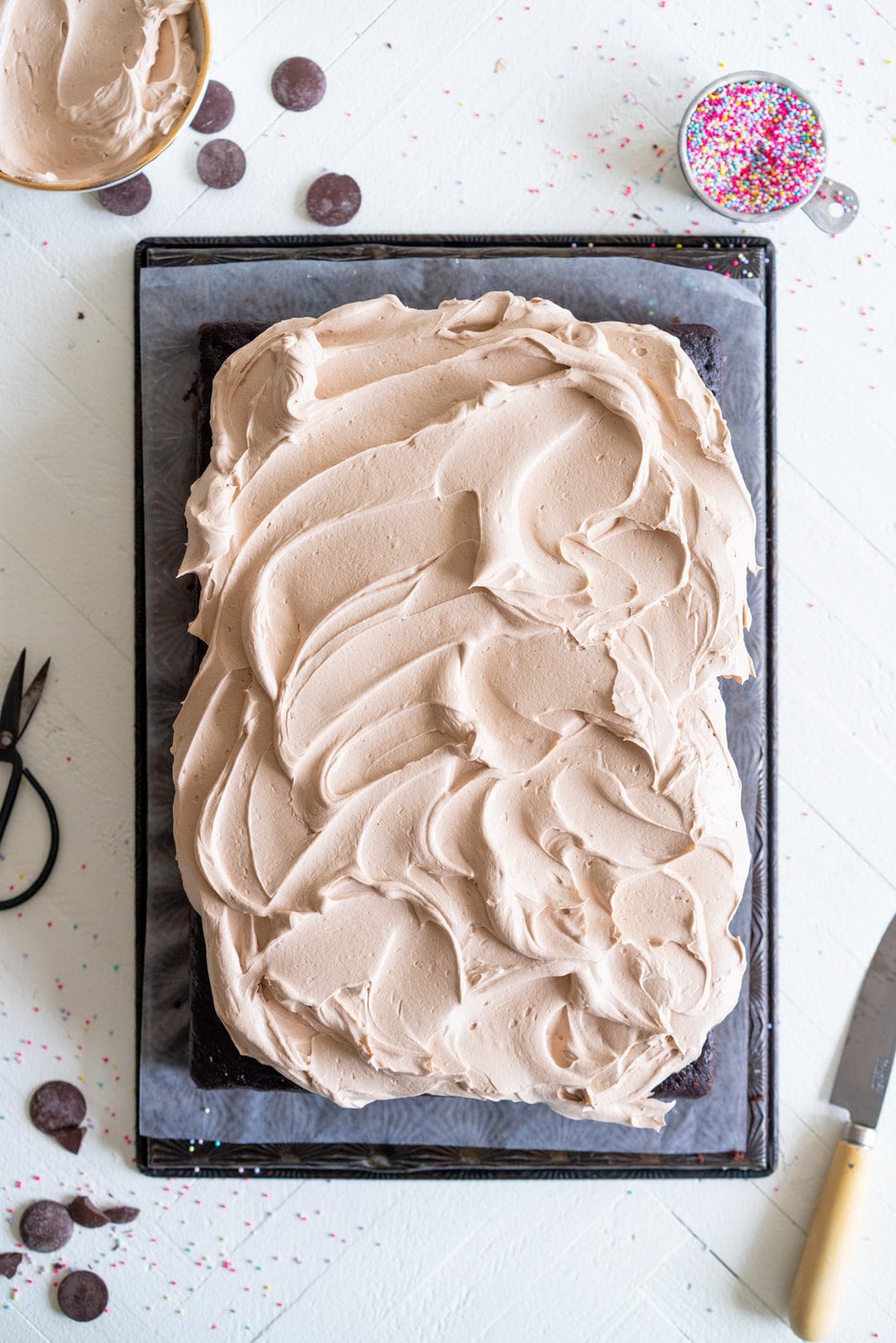 Chocolate sheet cake with milk chocolate german buttercream. This easy, from scratch chocolate sheet cake is enhanced with the flavour of olive oil, and bakes up nice and flat, making it the perfect sheet cake for decorating. It is topped with a silky, milk chocolate german buttercream. #sheetcake #germanbuttercream #chocolateoliveoilcake