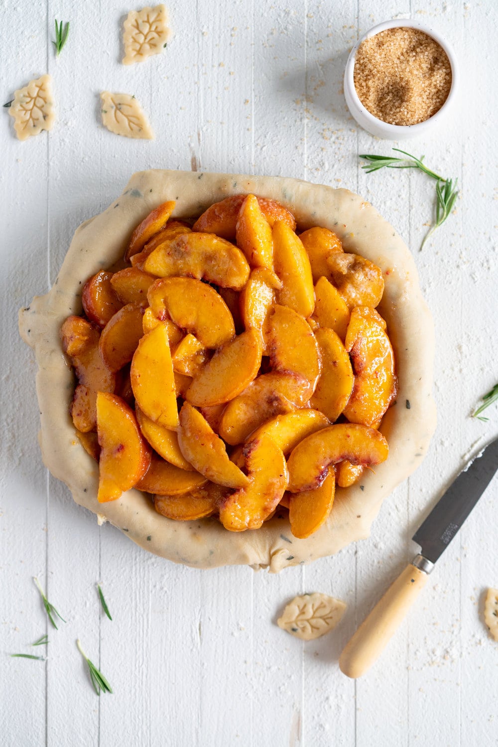Peach and Vanilla Bean Pie with Fresh Rosemary Pie Crust - sweet, summer peaches are elevated with vanilla bean paste, and wrapped up in a sweet pie crust filled with fresh rosemary. #peachpie #peachandrosemarypie