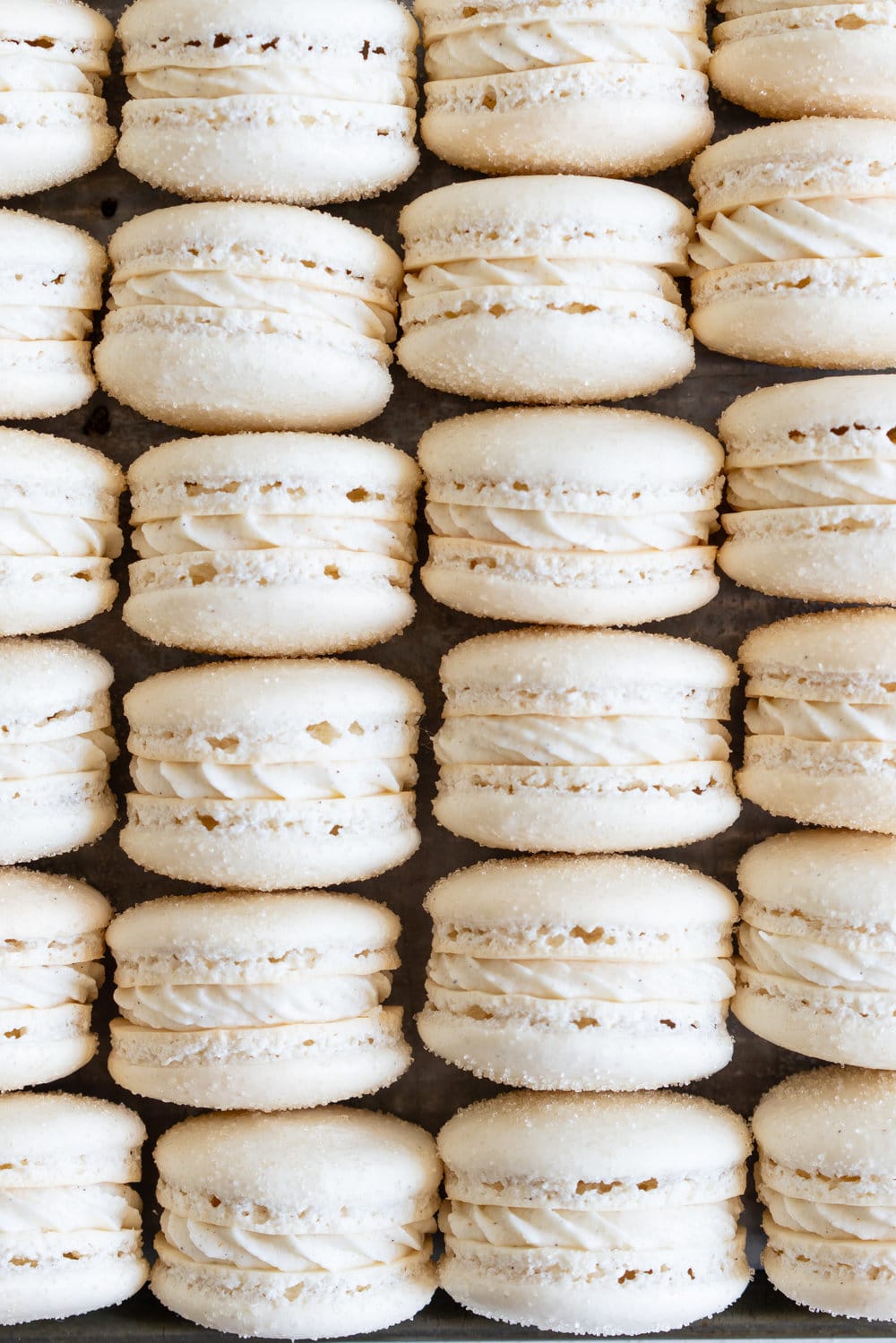 Golden Sugar Macarons with Cardamom Cream Cheese Filling. These French macarons are made with golden sugar, sprinkled with the sugar to give them a sparkly top, and filled with a smooth cardamom cream cheese filling. These are an easy gluten free treat, and this is a great go-to macaron recipe, filled with tips and tricks to help you master french macarons! #frenchmacarons #goldensugar #cardamomcreamcheese