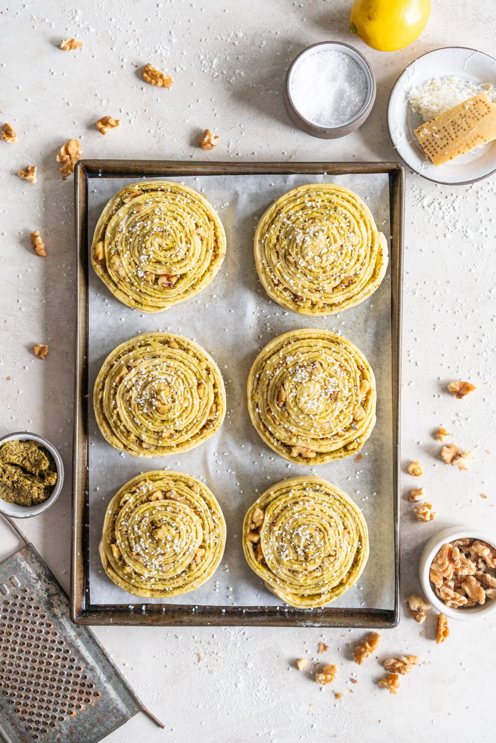 Laminated Brioche Pesto Buns with Lemon, Parmesan, and Walnut - buttery brioche is layered with zesty lemon, basil pesto and cheese, then sprinkled with walnuts and rolled up in to perfect pesto brioche pinwheel rolls. These are the perfect savoury take on a traditional laminated brioche #briocherolls #pestorolls #laminatedbrioche