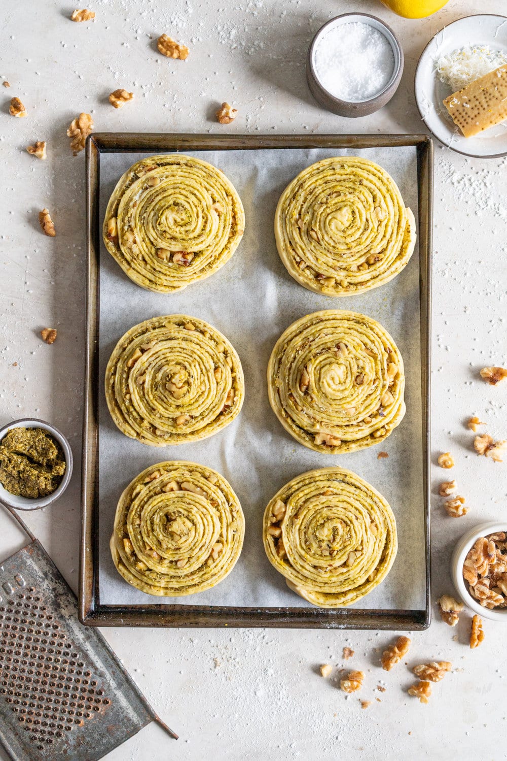 Laminated Brioche Pesto Buns with Lemon, Parmesan, and Walnut - buttery brioche is layered with zesty lemon, basil pesto and cheese, then sprinkled with walnuts and rolled up in to perfect pesto brioche pinwheel rolls. These are the perfect savoury take on a traditional laminated brioche #briocherolls #pestorolls #laminatedbrioche