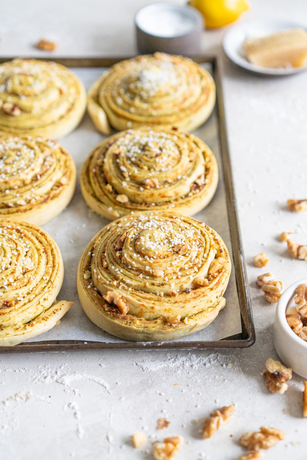 Laminated Brioche Pesto Buns with Lemon, Parmesan, and Walnut - buttery brioche is layered with zesty lemon, basil pesto and cheese, then sprinkled with walnuts and rolled up in to perfect pesto brioche pinwheel rolls. These are the perfect savoury take on a traditional laminated brioche #briocherolls #pestorolls #laminatedbrioche