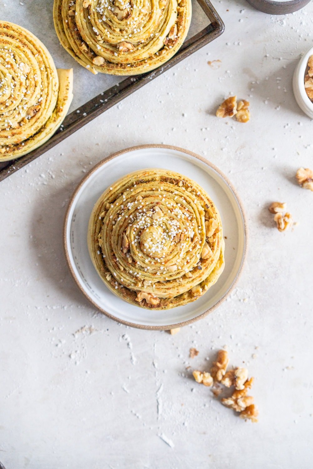 Laminated Brioche Pesto Buns with Lemon, Parmesan, and Walnut - buttery brioche is layered with zesty lemon, basil pesto and cheese, then sprinkled with walnuts and rolled up in to perfect pesto brioche pinwheel rolls. These are the perfect savoury take on a traditional laminated brioche #briocherolls #pestorolls #laminatedbrioche