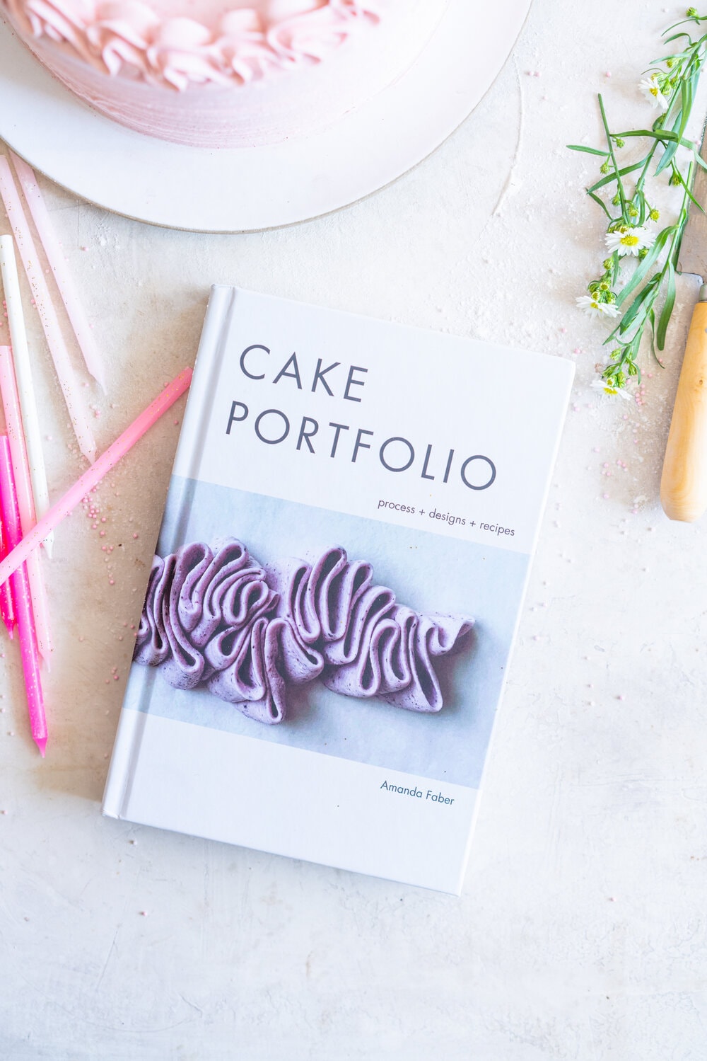 Chocolate Layer Cake with Jam Filling and Strawberry Swiss Meringue Buttercream from Amanda Faber's book, Cake Portfolio. Layers of Rich chocolate cake are layered up with mixed berry jam, and then the cake is finished with a strawberry swiss meringue buttercream made with freeze dried strawberry powder. This is the perfect birthday or celebration cake for anyone who loves strawberry or chocolate. #strawberryswissmeringuebuttercream #chocolatelayercake #layercake