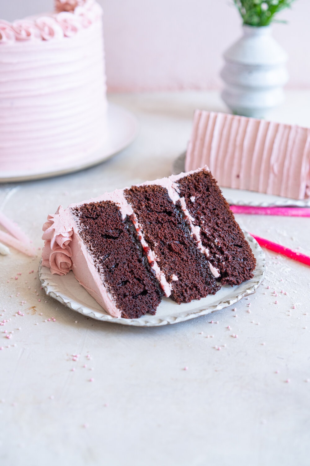 Chocolate Layer Cake with Jam Filling and Strawberry Swiss Meringue Buttercream from Amanda Faber's book, Cake Portfolio. Layers of Rich chocolate cake are layered up with mixed berry jam, and then the cake is finished with a strawberry swiss meringue buttercream made with freeze dried strawberry powder. This is the perfect birthday or celebration cake for anyone who loves strawberry or chocolate. #strawberryswissmeringuebuttercream #chocolatelayercake #layercake