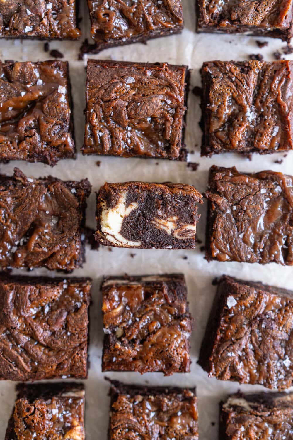 Peanut Butter Caramel Cream Cheese Swirl Brownies - fudgy brownies are swirled with a cheesecake cream cheese layer and then topped with a peanut butter caramel before being baked until fudgy and perfect. These are a must for any cheesecake or peanut butter lovers. #peanutbutterbrownies #creamcheesebrownies #cheesecakebrownies