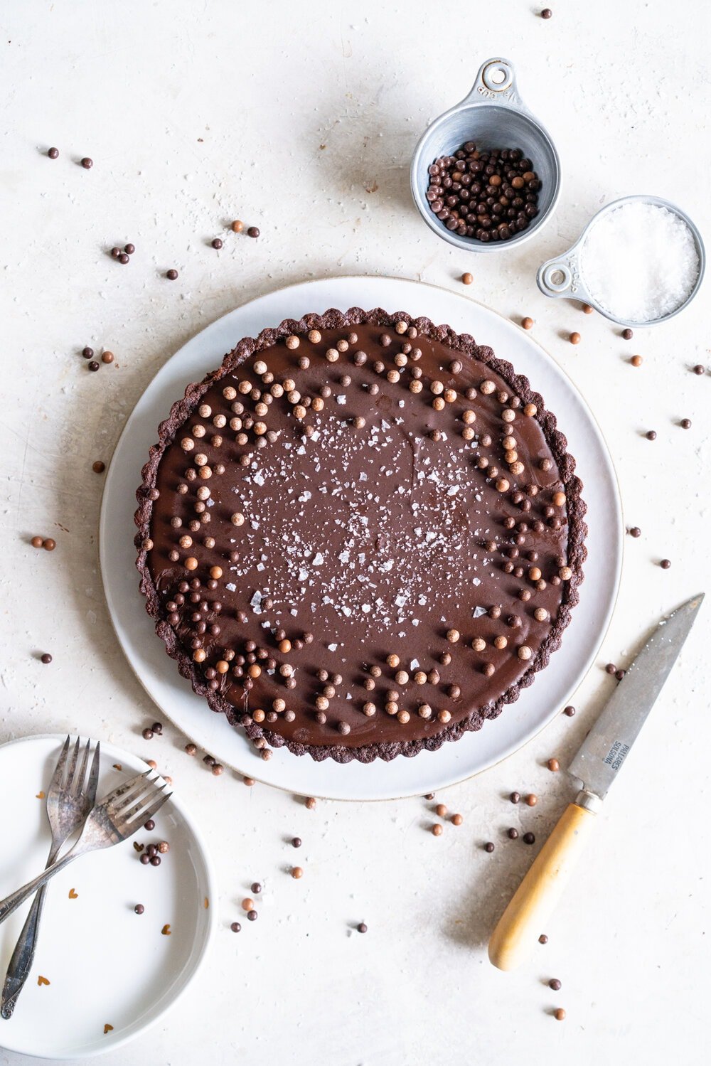 Olive Oil Chocolate Tart with Olive Oil Chocolate Press In Crust. This Olive oil tart has a super easy press in cookie crust made with olive oil, and is filled with a silky chocolate olive oil filling. The olive oil adds a beautiful depth of flavour, and the chocolate tart is finished with flaky sea salt. This is a perfect make ahead chocolate dessert that is great for feeding a crowd! #chocolatetart #chocolateoliveoiltart #pressincrust