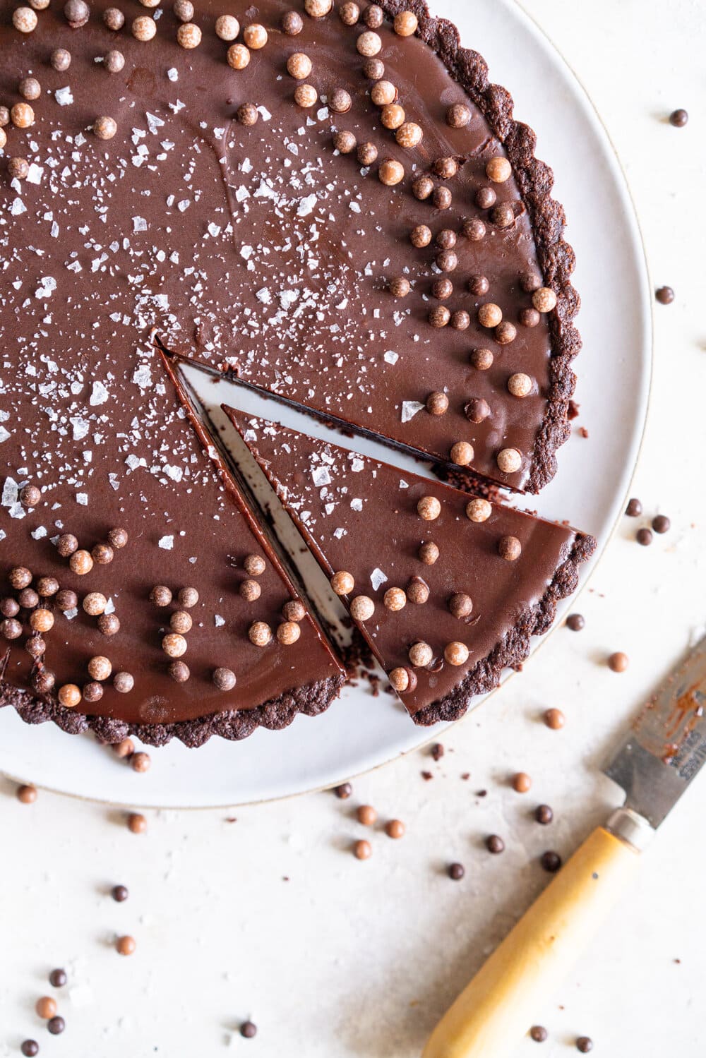 Olive Oil Chocolate Tart with Olive Oil Chocolate Press In Crust. This Olive oil tart has a super easy press in cookie crust made with olive oil, and is filled with a silky chocolate olive oil filling. The olive oil adds a beautiful depth of flavour, and the chocolate tart is finished with flaky sea salt. This is a perfect make ahead chocolate dessert that is great for feeding a crowd! #chocolatetart #chocolateoliveoiltart #pressincrust