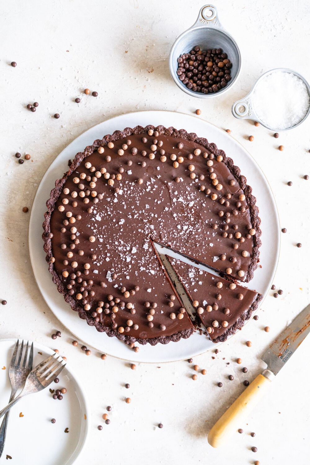 Olive Oil Chocolate Tart with Olive Oil Chocolate Press In Crust. This Olive oil tart has a super easy press in cookie crust made with olive oil, and is filled with a silky chocolate olive oil filling. The olive oil adds a beautiful depth of flavour, and the chocolate tart is finished with flaky sea salt. This is a perfect make ahead chocolate dessert that is great for feeding a crowd! #chocolatetart #chocolateoliveoiltart #pressincrust