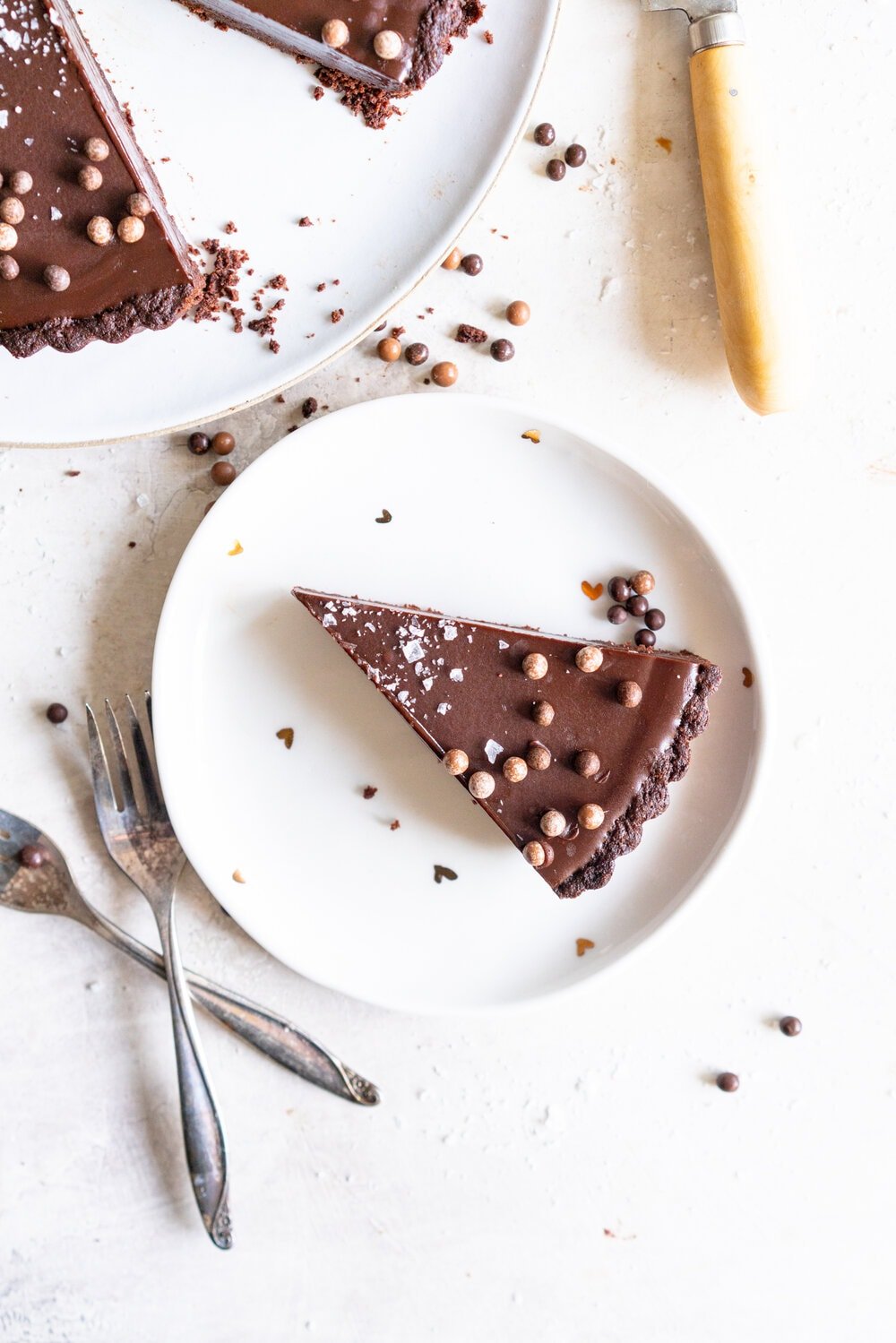 Olive Oil Chocolate Tart with Olive Oil Chocolate Press In Crust. This Olive oil tart has a super easy press in cookie crust made with olive oil, and is filled with a silky chocolate olive oil filling. The olive oil adds a beautiful depth of flavour, and the chocolate tart is finished with flaky sea salt. This is a perfect make ahead chocolate dessert that is great for feeding a crowd! #chocolatetart #chocolateoliveoiltart #pressincrust