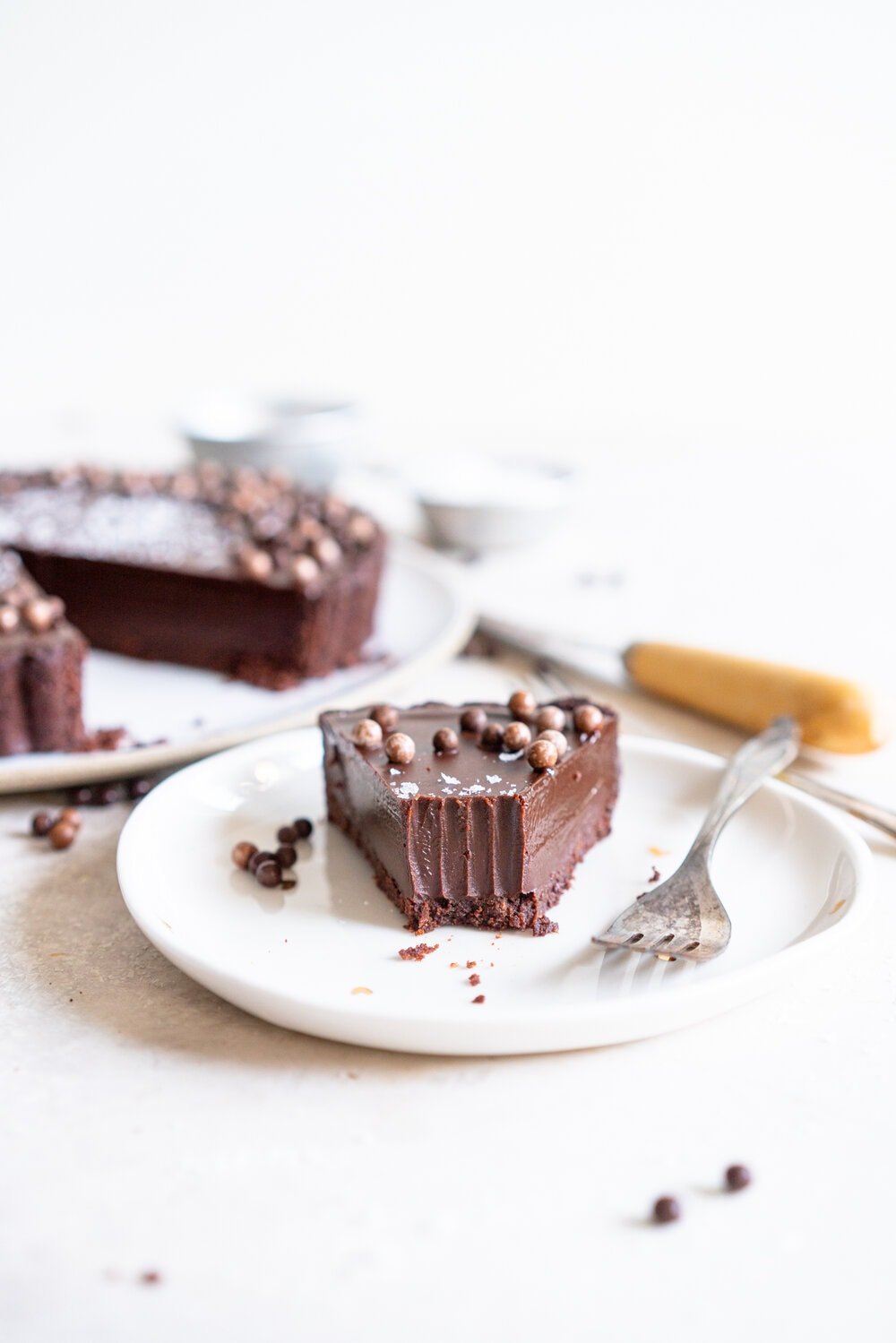 Olive Oil Chocolate Tart with Olive Oil Chocolate Press In Crust. This Olive oil tart has a super easy press in cookie crust made with olive oil, and is filled with a silky chocolate olive oil filling. The olive oil adds a beautiful depth of flavour, and the chocolate tart is finished with flaky sea salt. This is a perfect make ahead chocolate dessert that is great for feeding a crowd! #chocolatetart #chocolateoliveoiltart #pressincrust