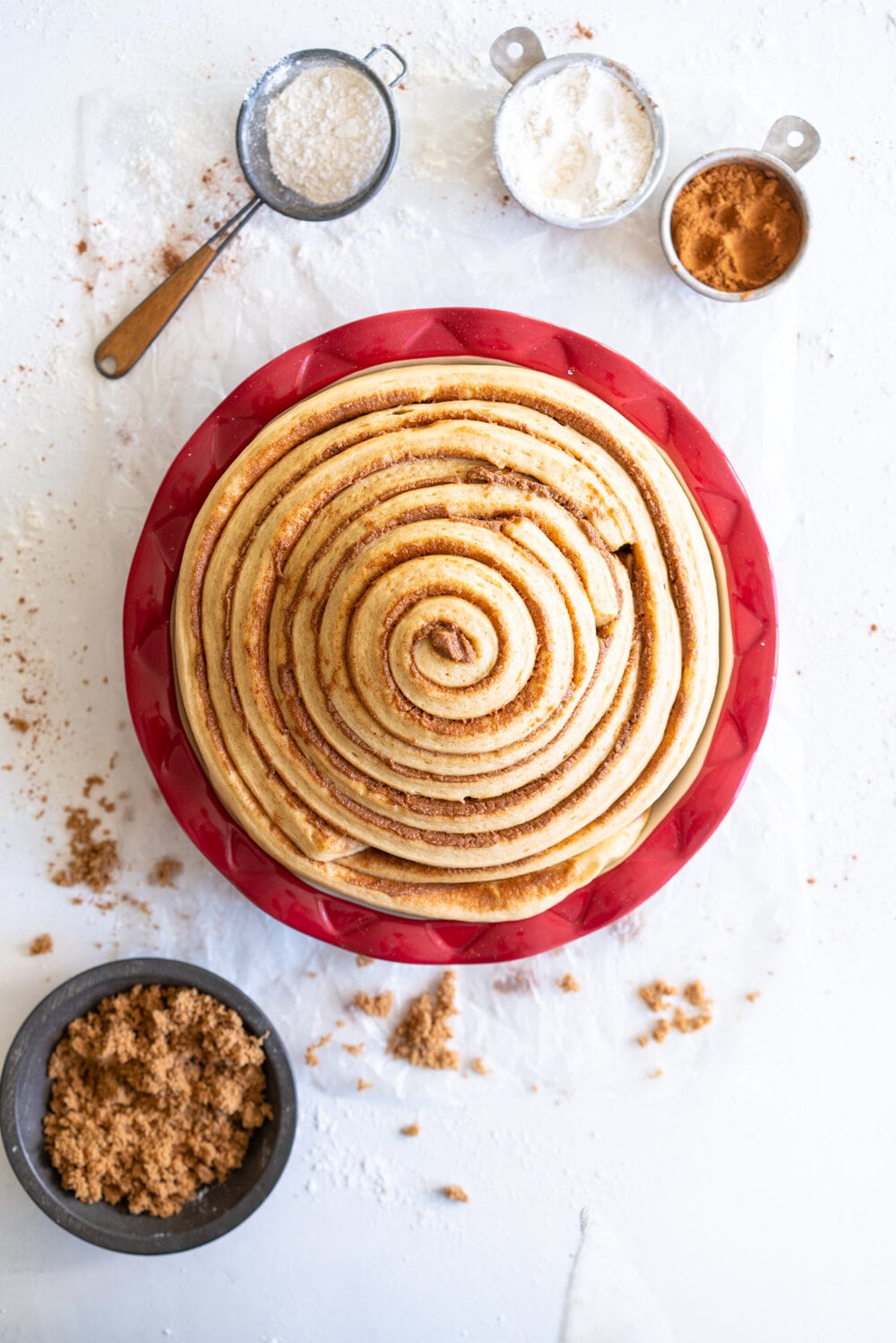 Giant Sour Cream Brioche Cinnamon Roll with Cream Cheese Frosting. A huge cinnamon roll, made from soft, pillowy brioche enriched with sour cream, is spread with a cinnamon sugar mixture and rolled up into a giant cinnamon roll which is baked until perfect and fluffy. It is then finished with a simple cream cheese frosting. This is the perfect holiday breakfast or brunch treat! #giantcinnamonroll #sourcreambrioche #creamcheesefrosting