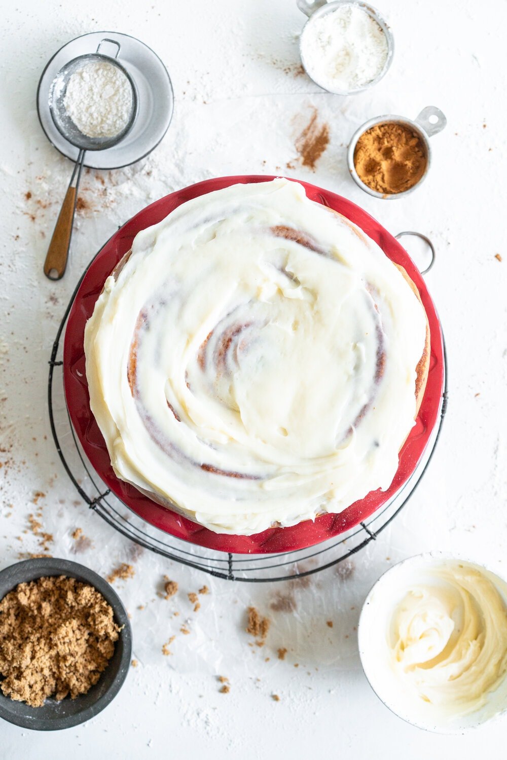 Giant Sour Cream Brioche Cinnamon Roll with Cream Cheese Frosting. A huge cinnamon roll, made from soft, pillowy brioche enriched with sour cream, is spread with a cinnamon sugar mixture and rolled up into a giant cinnamon roll which is baked until perfect and fluffy. It is then finished with a simple cream cheese frosting. This is the perfect holiday breakfast or brunch treat! #giantcinnamonroll #sourcreambrioche #creamcheesefrosting