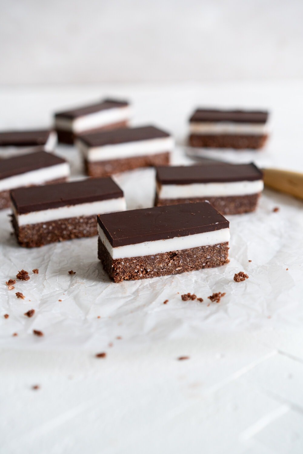 No-bake peppermint slice. A coconut chocolate graham crust is topped with a pepperminty icing layer, then finished with a thin, smooth layer of chocolate. This no bake take on a New Zealand classic is perfect for the holidays or any time sweet treat snacking. #peppermintslice #nobake