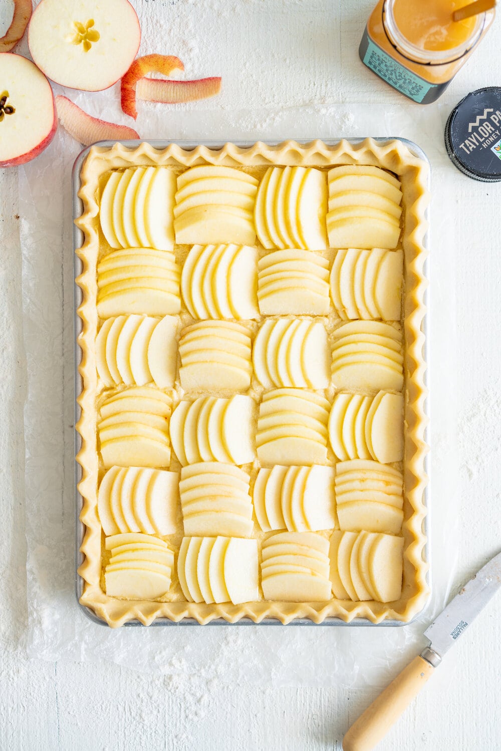 Open Apple Slab Pie with Honey Vanilla Bean Frangipane. Crispy, flaky pie dough is topped with a honey and vanilla bean frangipane mixture, covered with sliced apples, and baked to golden perfection. This is the perfect alternative to an apple pie for this holiday season. #appletart #applepie #frangipane #honeyfrangipane
