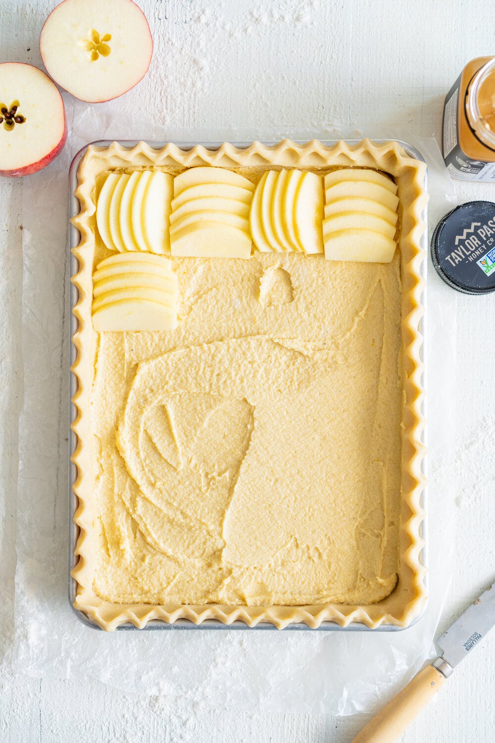 Open Apple Slab Pie with Honey Vanilla Bean Frangipane. Crispy, flaky pie dough is topped with a honey and vanilla bean frangipane mixture, covered with sliced apples, and baked to golden perfection. This is the perfect alternative to an apple pie for this holiday season. #appletart #applepie #frangipane #honeyfrangipane