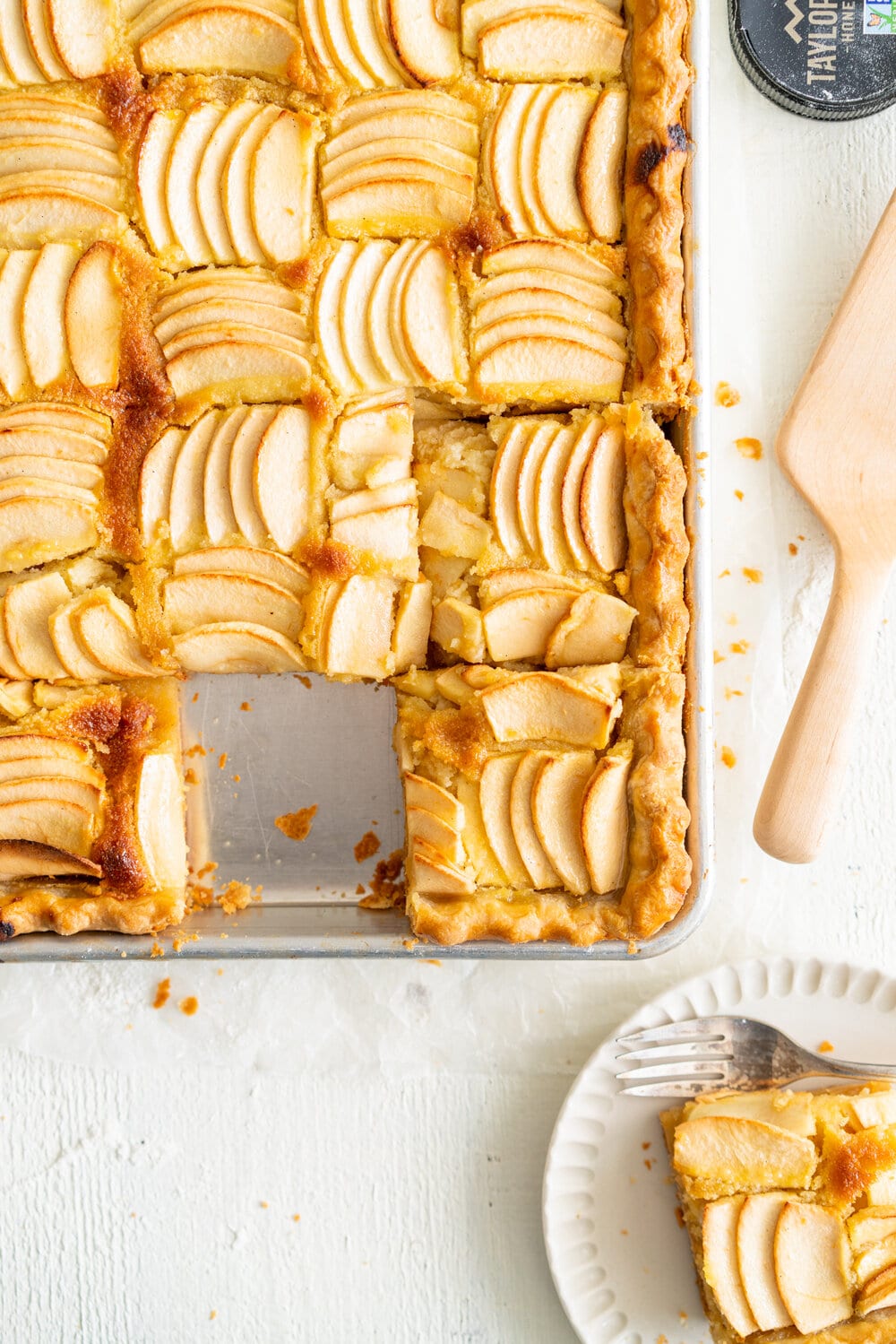 Open Apple Slab Pie with Honey Vanilla Bean Frangipane. Crispy, flaky pie dough is topped with a honey and vanilla bean frangipane mixture, covered with sliced apples, and baked to golden perfection. This is the perfect alternative to an apple pie for this holiday season. #appletart #applepie #frangipane #honeyfrangipane