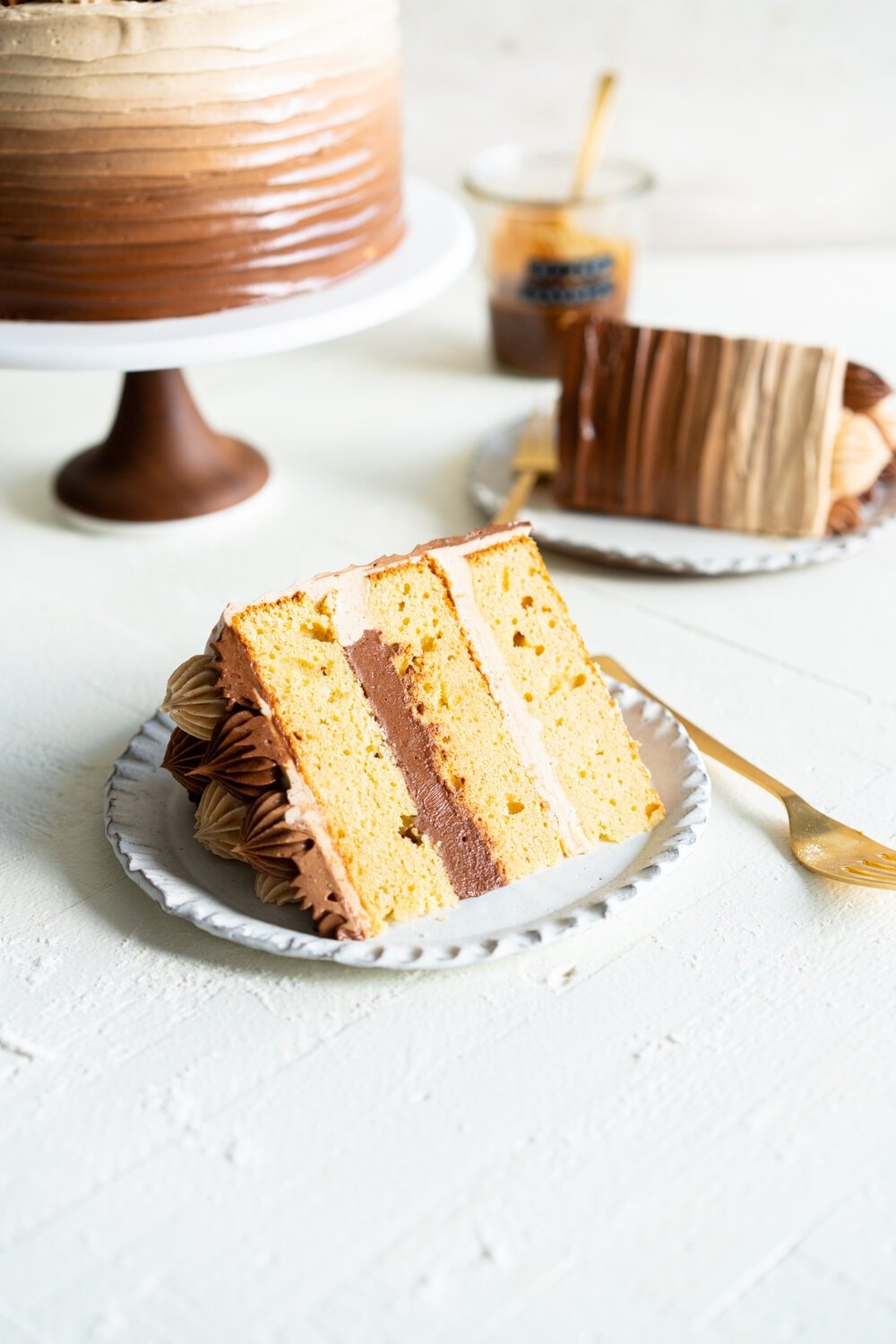 Apple Cider Layer Cake with Spiced Caramel Swiss Meringue Buttercream. This layer cake has reduced apple cider added to the batter, giving it a delicate apple flavour. It is finished with spiced salted caramel swiss meringue buttercream with an ombre finish.  #applecidercake #caramelbuttercream #swissmeringue