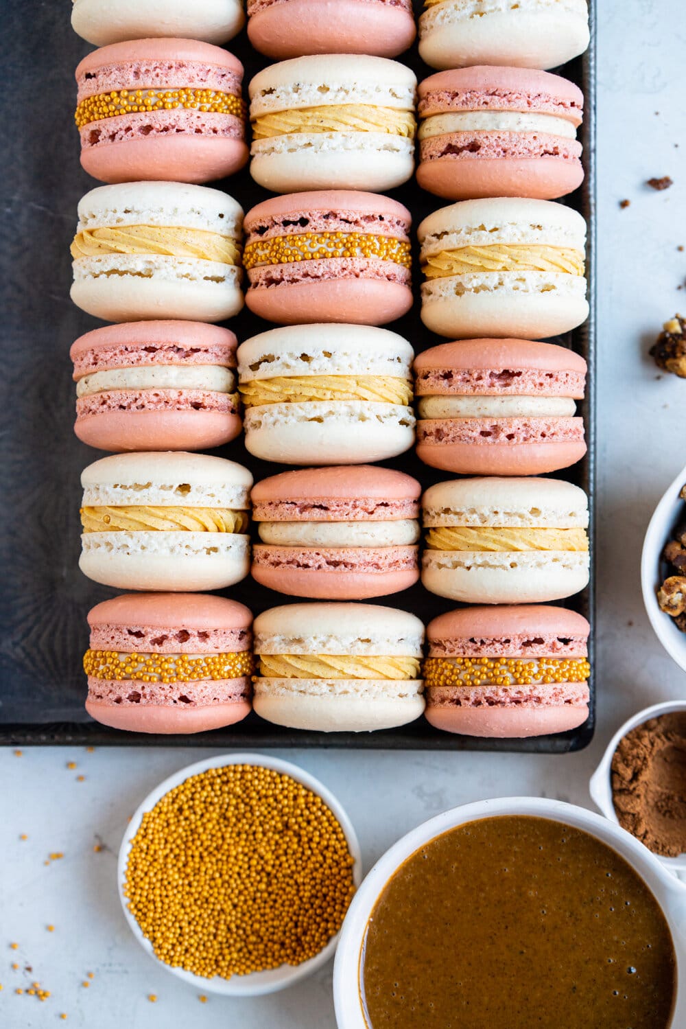 Spiced Pumpkin and Walnut Praline macarons. These are thanksgiving inspired macarons, with a walnut praline swiss meringue buttercream and a spiced pumpkin swiss meringue buttercream, these easy, no-fail french macarons are a perfect addition to your holiday dessert table.