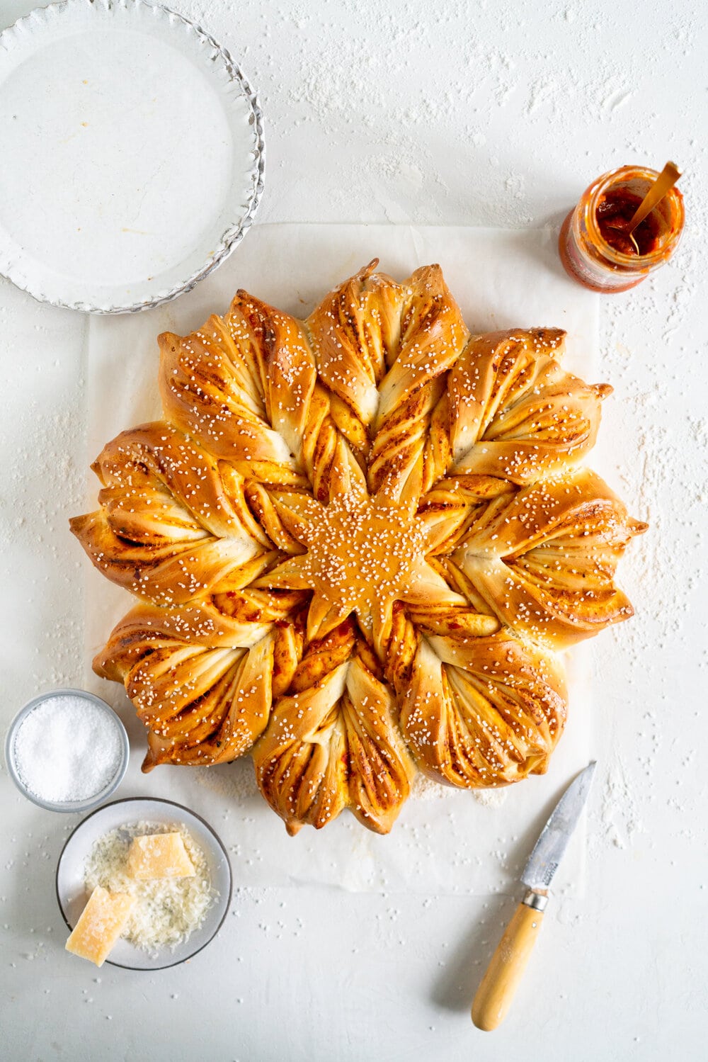 Spicy Tomato Pesto and Parmesan Star Bread. Brioche dough is layered with spicy tomato pesto and parmesan, then twisted into an easy but beautiful star bread which is perfect for tearing and sharing.