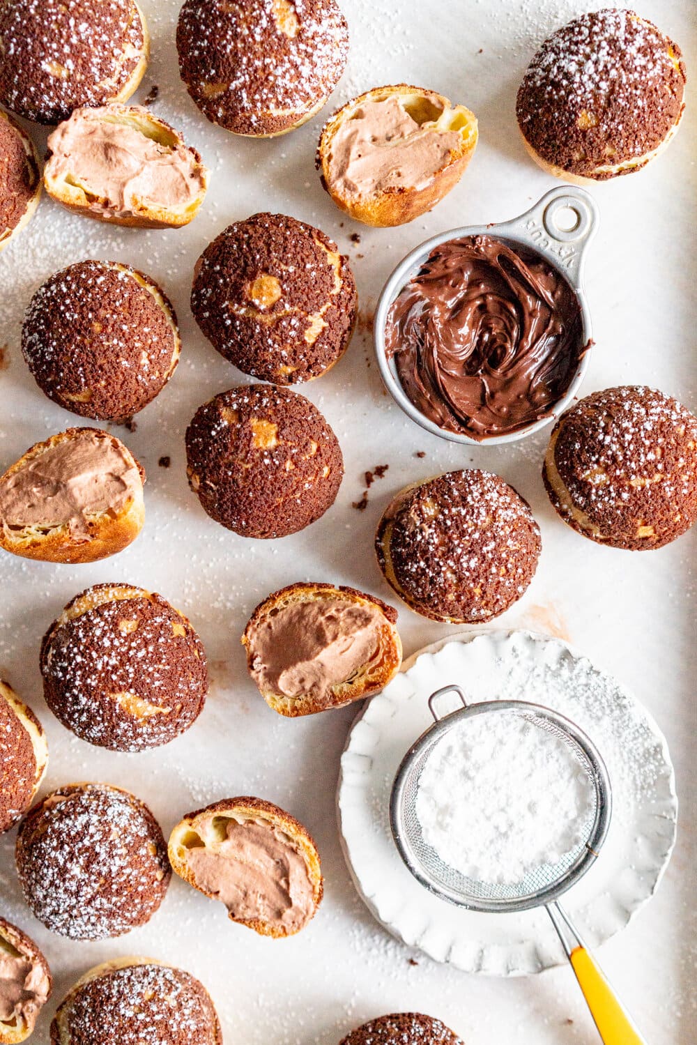 Chocolate Choux au Craquelin with Chocolate Hazelnut Whipped Cream Filling. Rounds of Choux dough are topped with chocolate craquelin and baked to perfection, then filled with silky chocolate hazelnut whipped cream #chouxaucraquelin #creampuffs #chocolatehazelnut