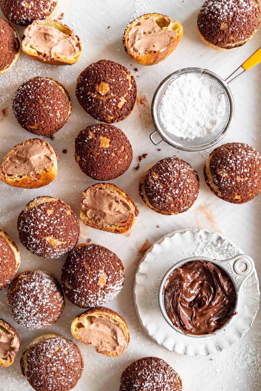 Chocolate Choux au Craquelin with Chocolate Hazelnut Whipped Cream Filling. Rounds of Choux dough are topped with chocolate craquelin and baked to perfection, then filled with silky chocolate hazelnut whipped cream #chouxaucraquelin #creampuffs #chocolatehazelnut