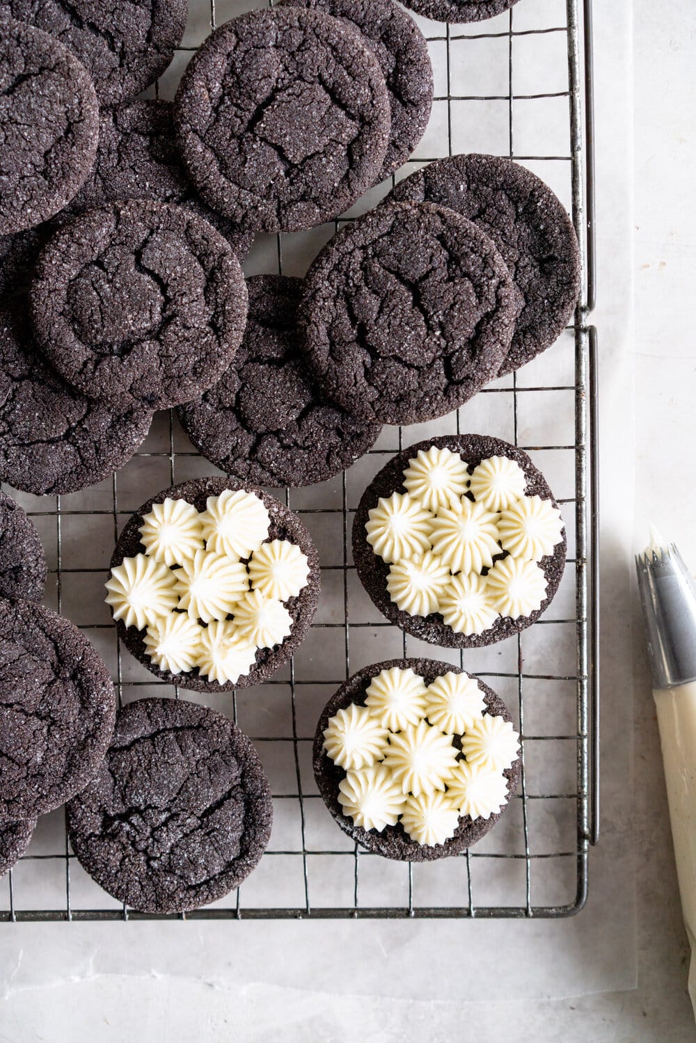 Black Cocoa Sugar Cookie Sandwiches with Cream Cheese Buttercream are the perfect 'grown-up oreo' treat! Soft, chewy black cocoa sugar cookies are paired with a smooth cream cheese frosting to make the perfect sugar cookie sandwich.