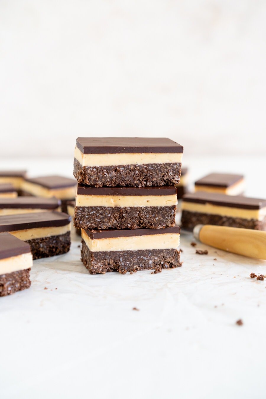 No-Bake Nanaimo Bars - a graham cracker and coconut base is topped with a smooth custard American buttercream and finished off with a super smooth layer of dark chocolate. These are a classic bar, and this no-bake version is so so easy to make!