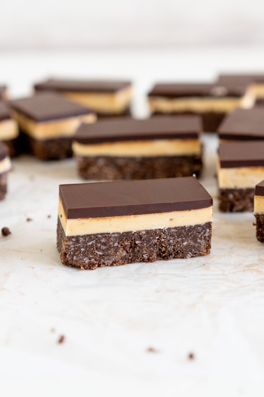 No-Bake Nanaimo Bars - a graham cracker and coconut base is topped with a smooth custard American buttercream and finished off with a super smooth layer of dark chocolate. These are a classic bar, and this no-bake version is so so easy to make!
