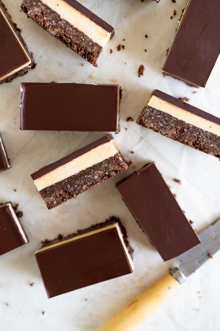 No-Bake Nanaimo Bars - a graham cracker and coconut base is topped with a smooth custard American buttercream and finished off with a super smooth layer of dark chocolate. These are a classic bar, and this no-bake version is so so easy to make!