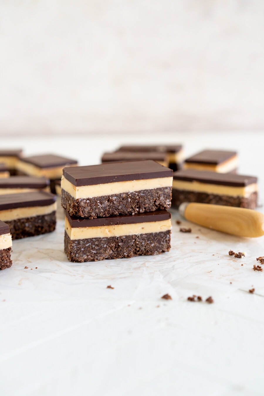 No-Bake Nanaimo Bars - a graham cracker and coconut base is topped with a smooth custard American buttercream and finished off with a super smooth layer of dark chocolate. These are a classic bar, and this no-bake version is so so easy to make!
