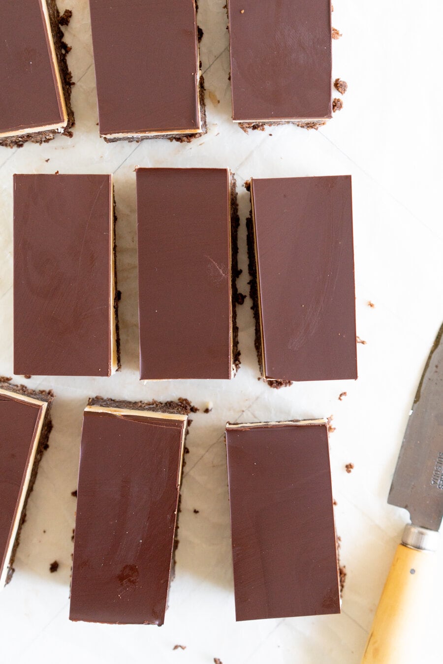 No-Bake Nanaimo Bars - a graham cracker and coconut base is topped with a smooth custard American buttercream and finished off with a super smooth layer of dark chocolate. These are a classic bar, and this no-bake version is so so easy to make!