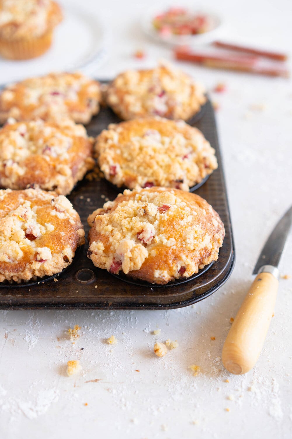 Rhubarb Streusel Muffins - a moist muffin base is studded with fresh rhubarb chunks and topped with a crunchy streusel crumble topping which is lightly flavoured with lemon zest and vanilla. This easy streusel muffin recipe can be made with any fruit but is perfect made with fresh rhubarb.