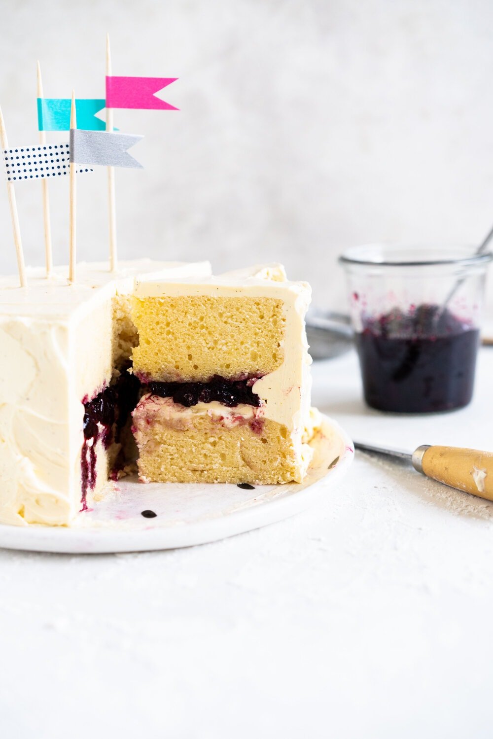 Two Layer Vanilla Bean Buttermilk Cake with Cherry Compote and Vanilla Bean Swiss Meringue Buttercream. This small two-layer cake is perfect for a celebration with a small group. The cake is tender from the reverse creaming method, and the Swiss meringue buttercream is smooth and silky. This is the perfect vanilla bean cake!