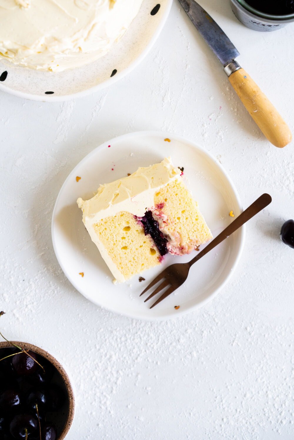 Two Layer Vanilla Bean Buttermilk Cake with Cherry Compote and Vanilla Bean Swiss Meringue Buttercream. This small two-layer cake is perfect for a celebration with a small group. The cake is tender from the reverse creaming method, and the Swiss meringue buttercream is smooth and silky. This is the perfect vanilla bean cake!