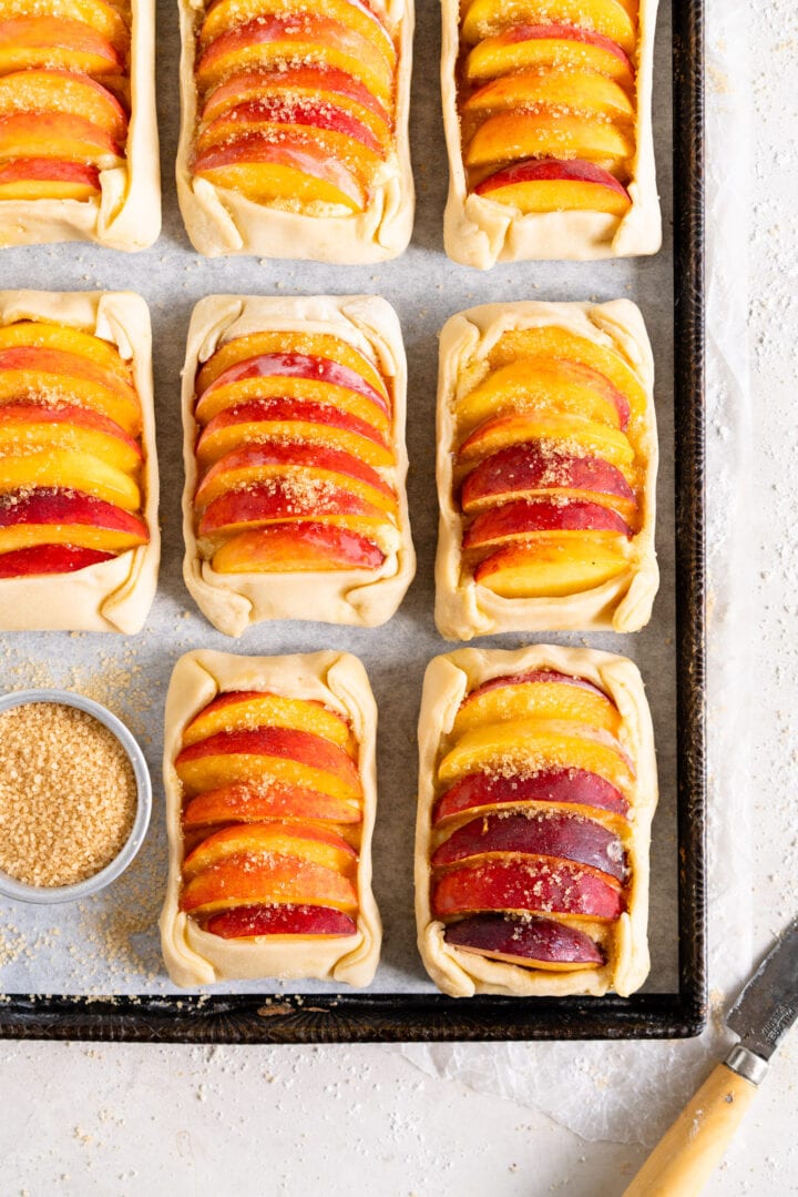 Side image of peach galettes on a sheet pan