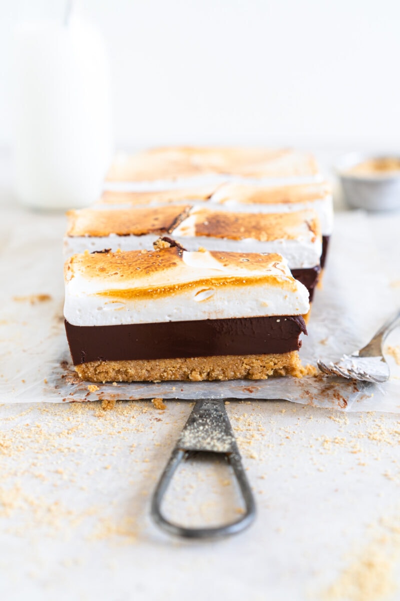 Side on shot of S'mores bars showing graham cracker crust, chocolate filling and marshmallow topping
