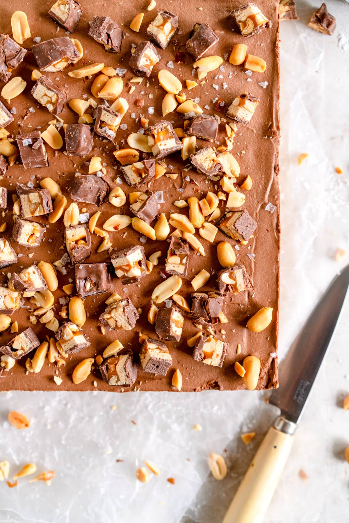 top down shot of chocolate cheesecake with chopped candy bars