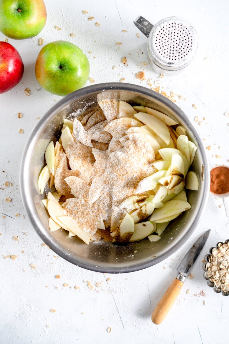 sliced apples in bowl with flour and sugar