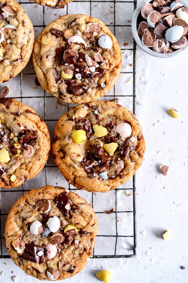 cookies on wire rack with mini eggs in container