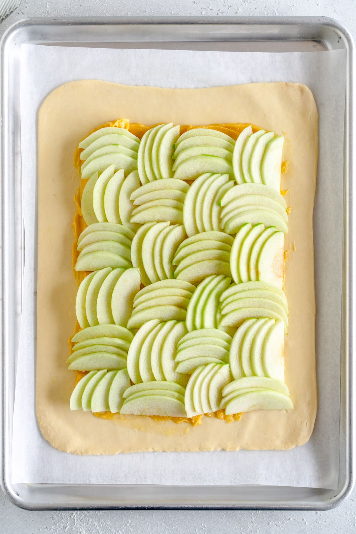 sliced apples on apple galette