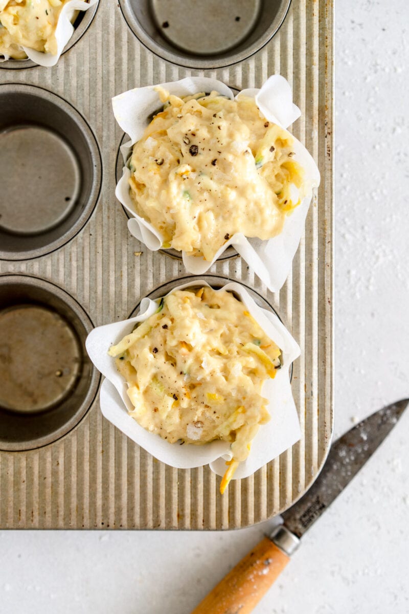 zucchini muffins in parchment paper liner ready to bake