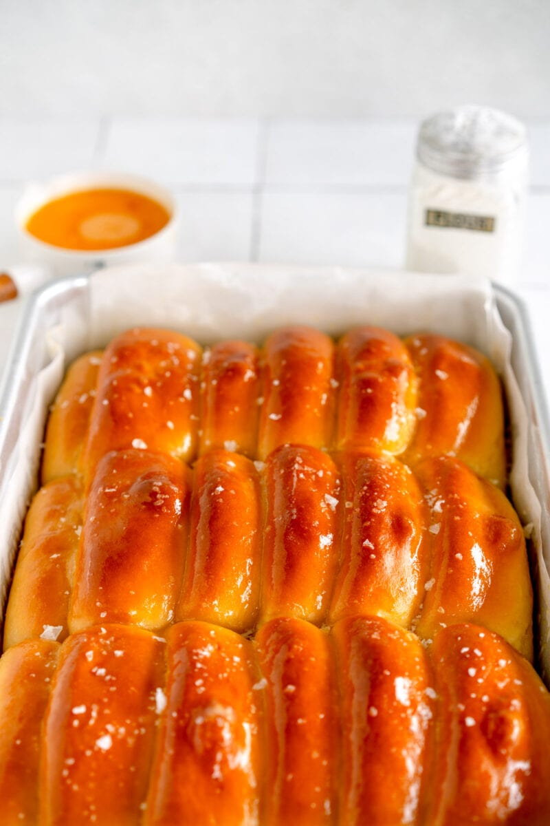 tray of baked parker house rolls brushed with butter and finished with salt