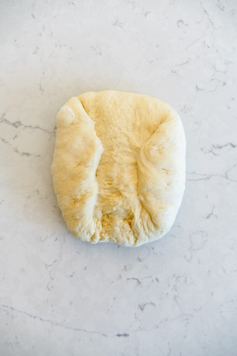 shaping bread dough into a loaf shape