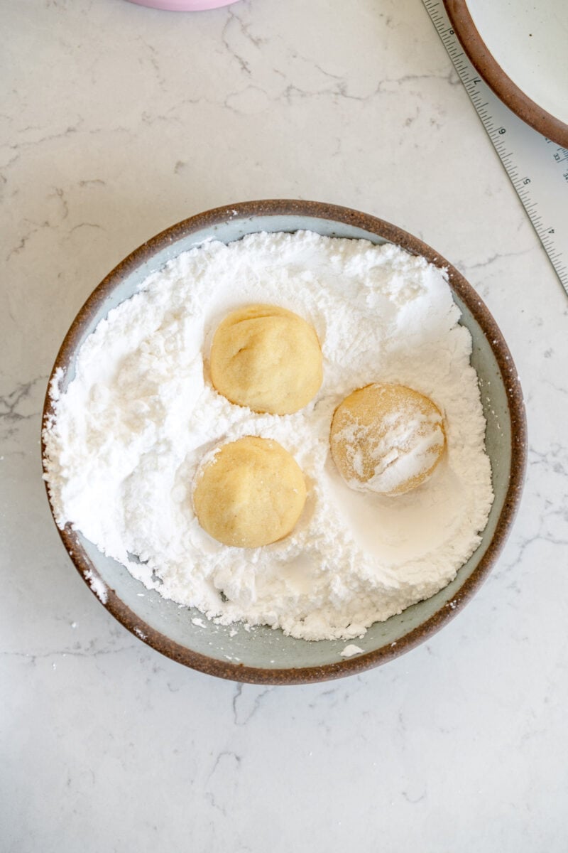 rolling cookies in powdered sugar