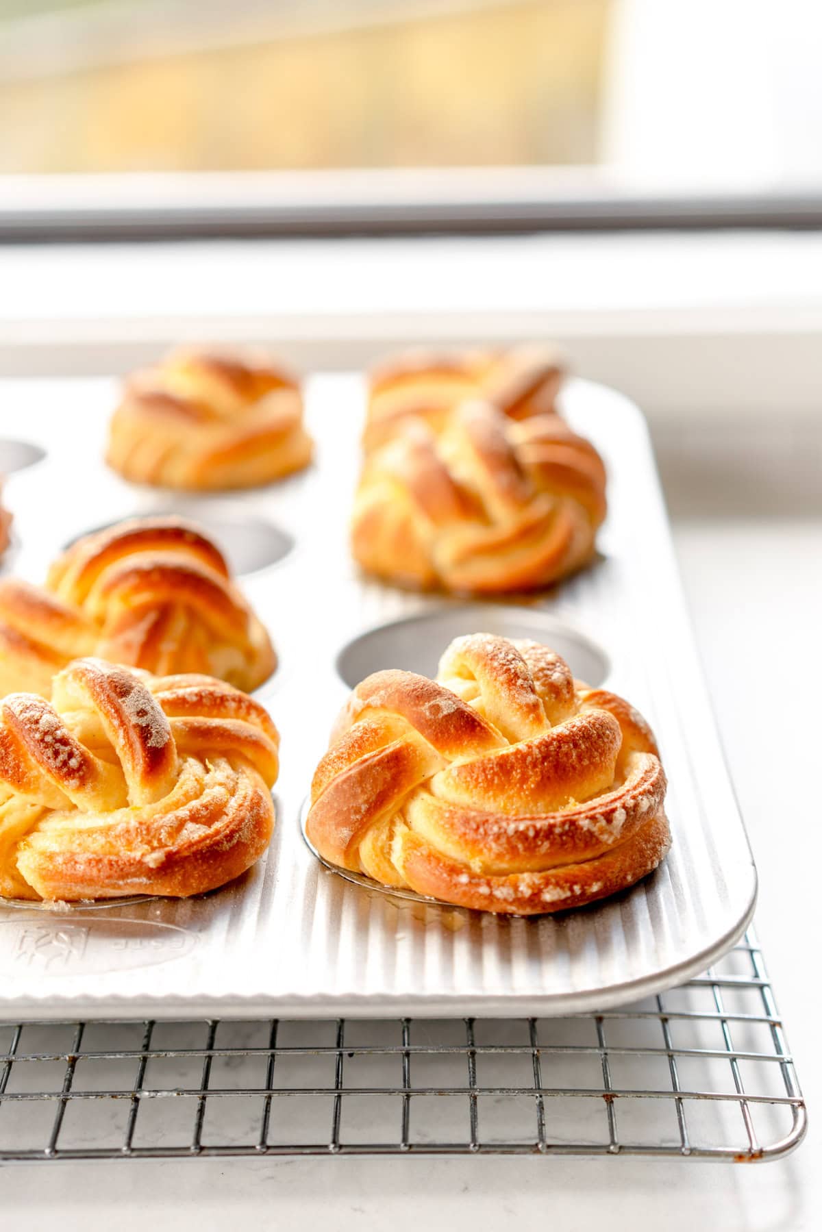 side on image of baked lemon buns in muffin pan